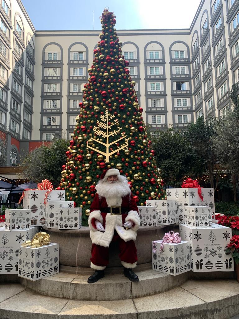Santa Claus frente al árbol de Navidad